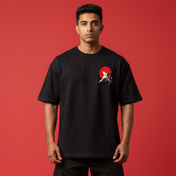 Person wearing a black t-shirt with a graphic design on a red background